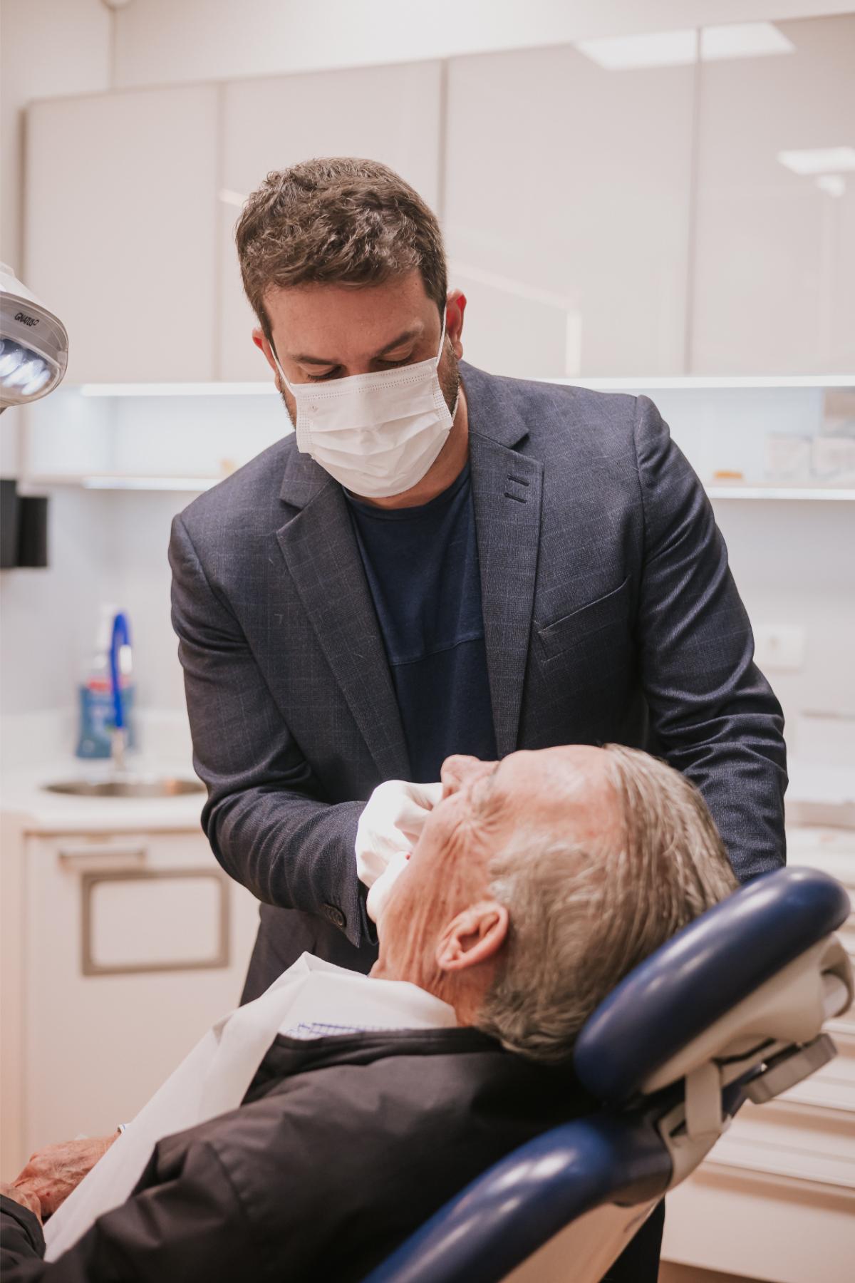 Dentista da SB Odontologia atendendo paciente em tratamento de protocolo sobre implantes