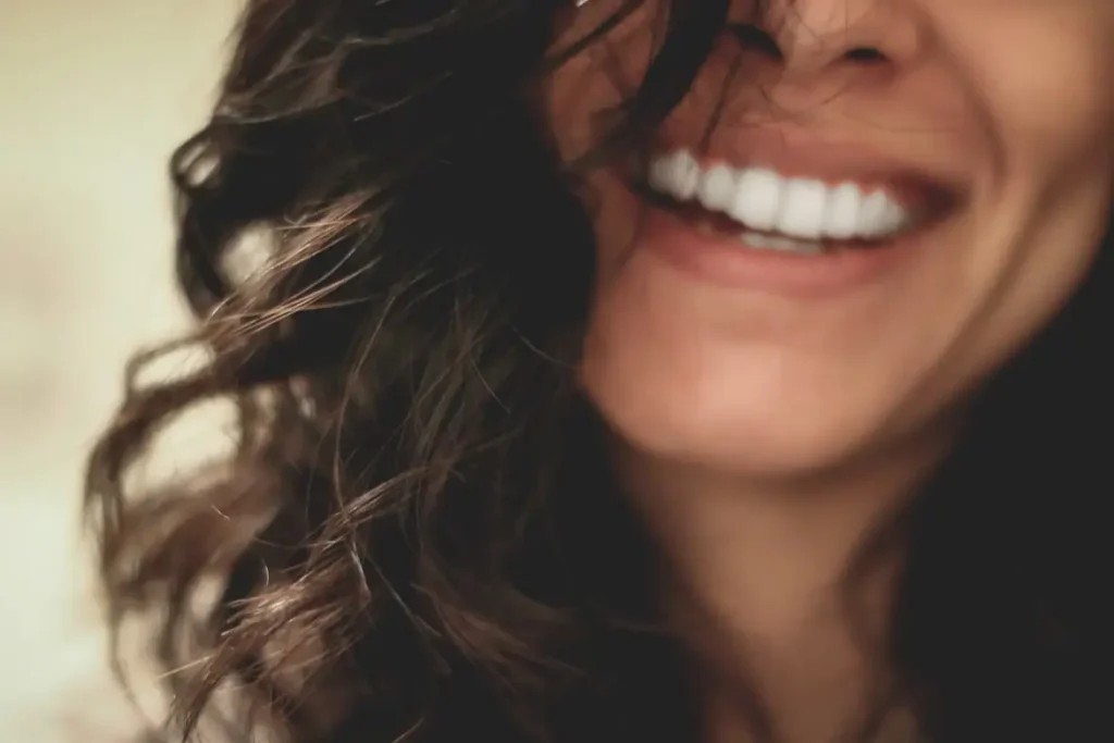 mulher sorrindo representando a estética dentária avançada que oferece sorriso perfeito"